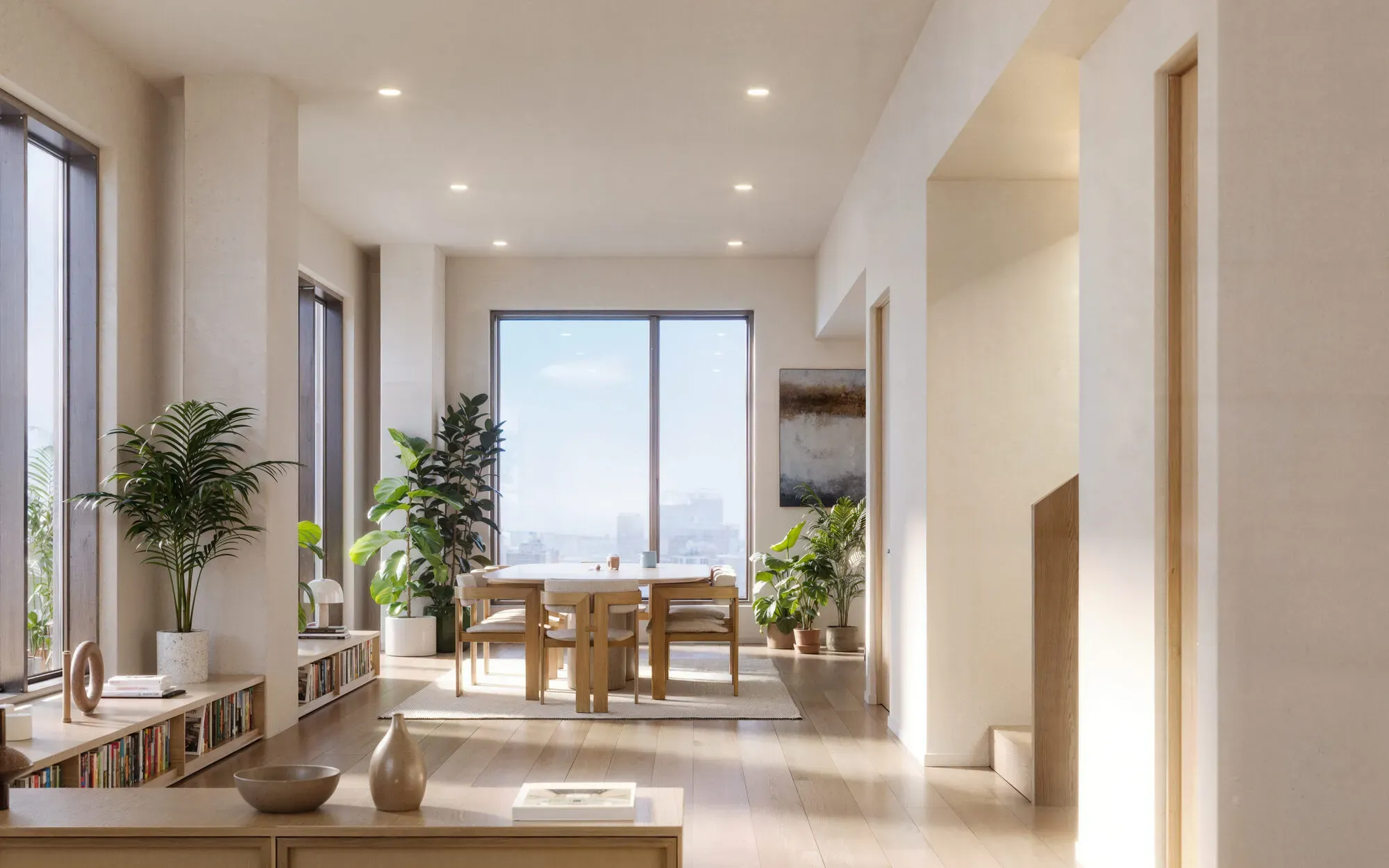 Bright modern apartment interior with large windows, wooden dining table, potted plants, and city view